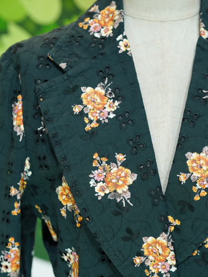 くすんだ深緑地の刺繍地に橙などの花柄ジャケット
