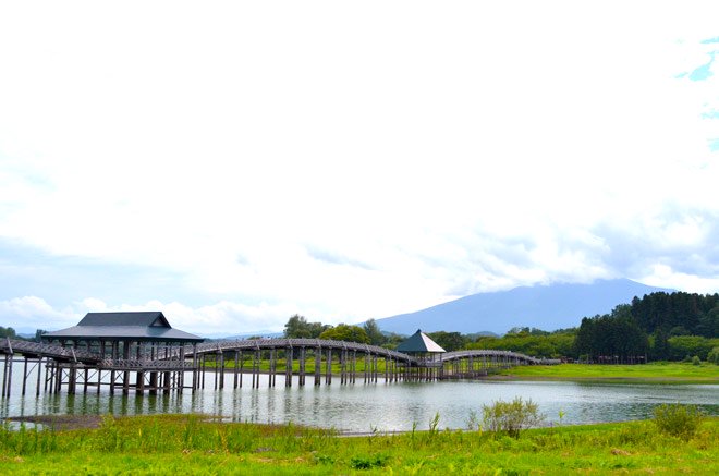 全長300メートルもの日本一長い木造三連太鼓橋。岩木山を背景に鶴が空に舞っているような優美さがある橋です。